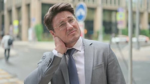 Businessman Rubbing Neck in the City
