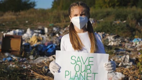 Child Holds Save Our Planet Sign in Landfill