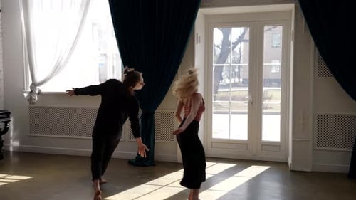 Beautiful Woman and Young Man are Dancing Together in Light Hall Whirling and Moving Slowly