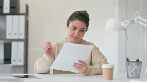 Woman Reads Documents in an Office Environment