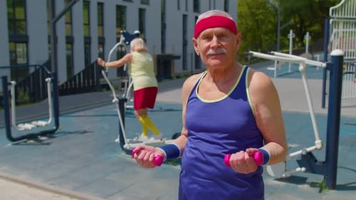 Senior Man Grandfather Doing Active Training Weightlifting Exercising with Dumbbell on Playground