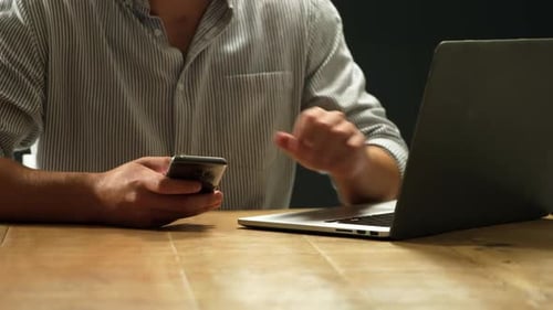Man using smartphone and laptop