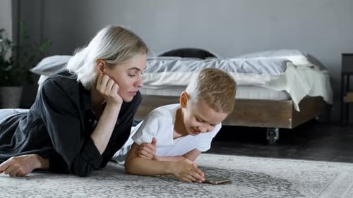 Mother and Son Using Cell Phone on Floor