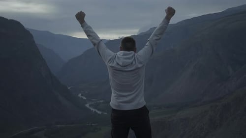 Man With Outstretched Hands At The Top Of A Mountain