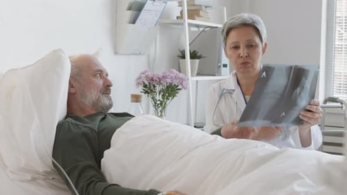 Female Doctor Discussing X-ray Pic with Senior Man