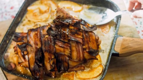 Basting Bacon-Wrapped Pork with Apples and Sausage