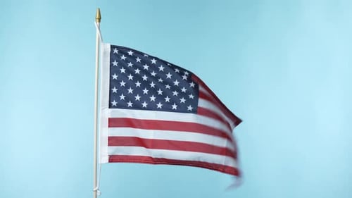 American Flag Waving Against Blue Background