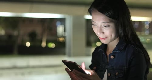 Woman Using Smartphone at Night Outdoors