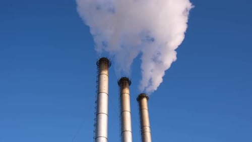 Smokestacks Billowing Smoke Against the Blue Sky