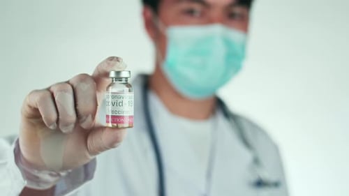 Medical Worker Holding COVID-19 Vaccine Vial