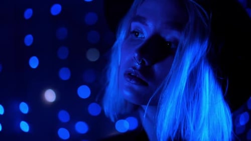 Glamorous Woman Posing in Blue Lights at Night