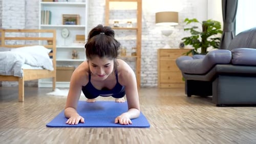 Woman Doing Plank Exercise on Mat at Home