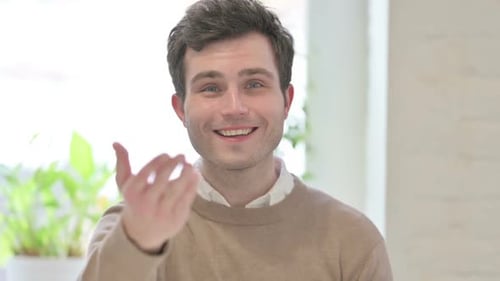 Smiling Man Beckons Viewer to Come Closer