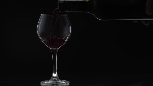 Wine Pouring Into Glass on Black Background