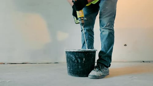 Man Mixing Plaster with Drill Indoors