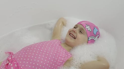 Happy Young Child Relaxing in a Bubble Bath