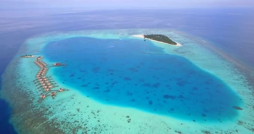 Vista aérea de drone da pitoresca ilha tropical e hotel resort com bangalôs sobre a água nas Maldivas