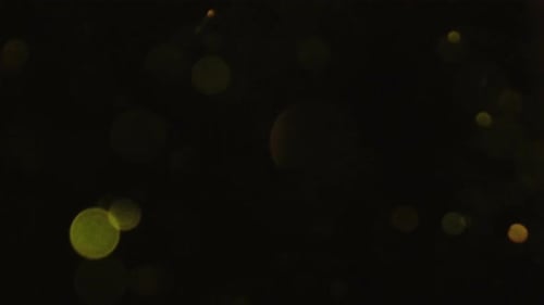 Abstract Gold Particles Stream Across Black Background