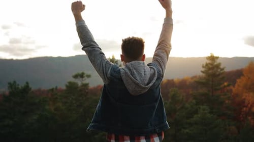 Teen Victorious on Mountain Top at Sunset