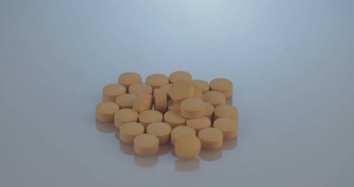 Pile of Tan Pills on Gray Background