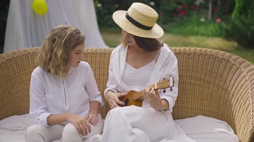 Woman and Child Playing Ukulele in Garden