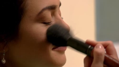 Adult Woman Applying Makeup with a Soft Brush