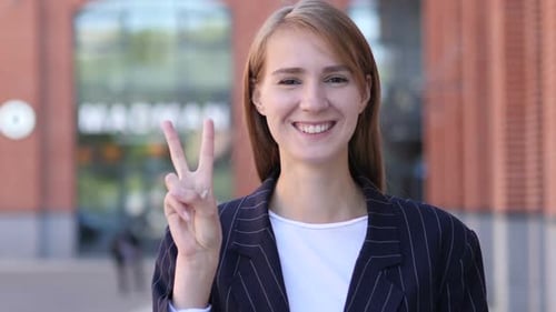 Victory Sign By Positive Business Woman