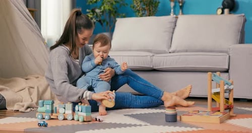 Mother and Baby Playing With Wooden Toys at Home