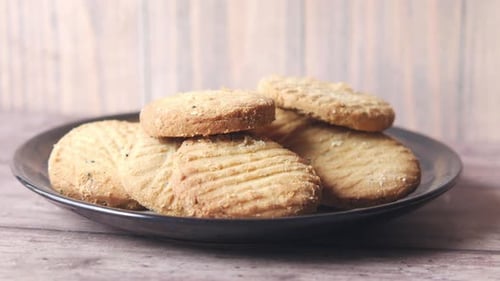 Crispy Cookies on a Plate, Hand Reaching In