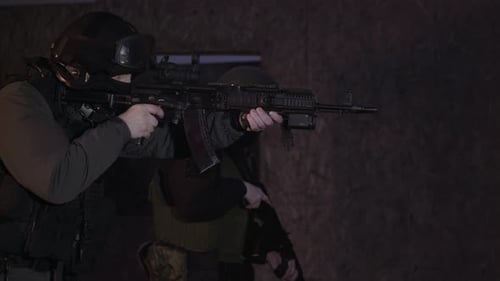 Armed Men Holding Rifles Patrol Room at Night