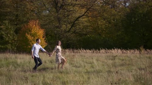Young Couple Walking on a Meadow