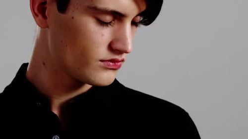 Young Man in Black Shirt Looks at Camera