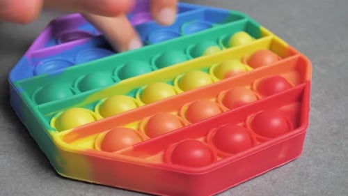 Hands Playing with Colorful Pop It Fidget Toy
