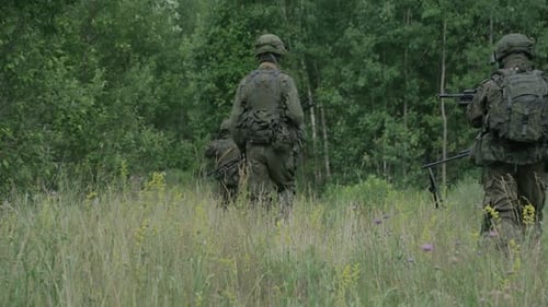 Soldiers in Camouflage with Assault Rifle Walking Through the Field Military Action in the Steppe