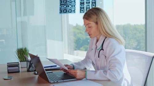 Female Doctor Analyzing Documents at Desk