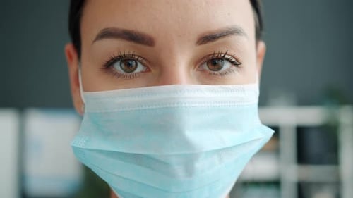 Portrait of Beautiful Young Woman Doctor Wearing Face Mask Indoors in Office