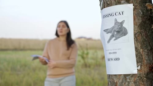Woman Gives Flyer to Person Focus on Missing Cat Poster
