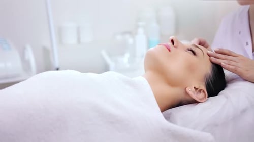 Woman Receiving Facial Massage in Treatment Room