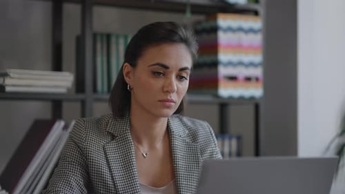 A Young Beautiful Woman is Sitting on a Chair and Writing Down or Taking Down Notes While Attending