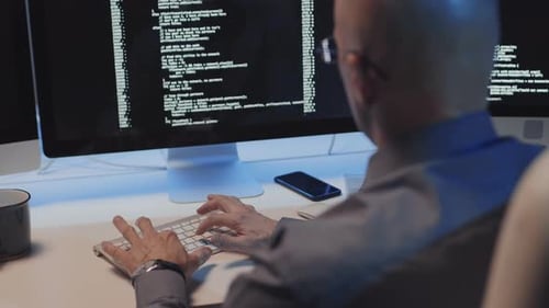 Mature Man Coding at Desk