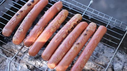 Vue en gros plan de délicieuses saucisses grillées sur la grille du gril à charbon