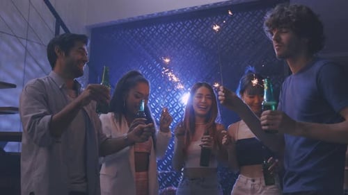 Friends Celebrating with Sparklers and Drinks at Party