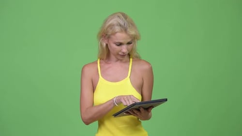 Blonde Woman Using a Tablet on Green Screen