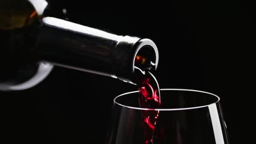Pouring Red Wine into a Glass on Black