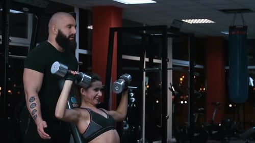 Woman Lifting Weights with Personal Trainer