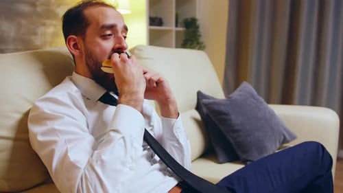 Man On Couch Talking On Cell Phone Eating