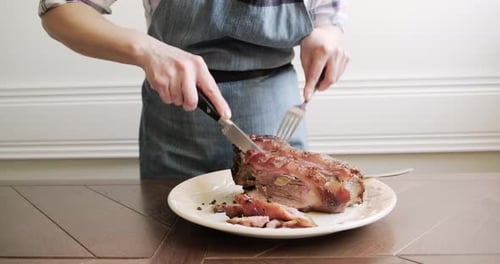Cutting Roasted Ham on a Plate Indoors