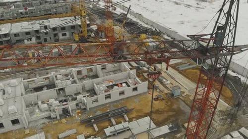Orange Construction Crane Against Unfinished Buildings