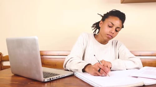 Schöne Frau gemischter Abstammung, die zu Hause studiert oder arbeitet