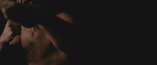 Muscular Man Boxing in Dark Environment